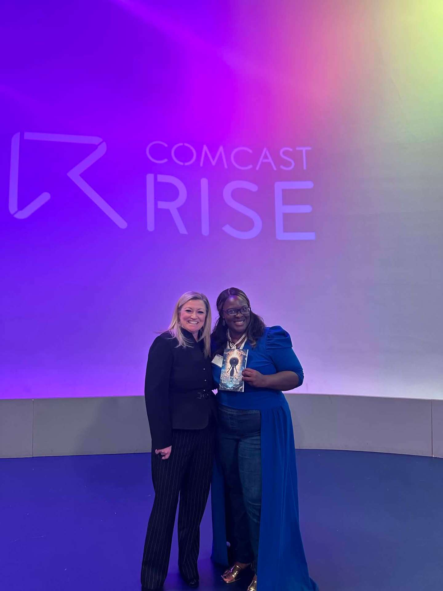 Ashlee Marie at Comcast RISE event holding Blessed and Bad 2 The Bone
